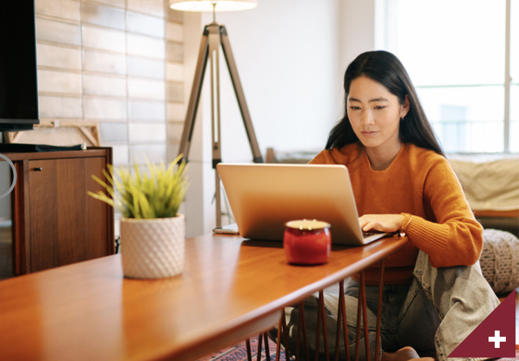 Woman works at home on computer at table