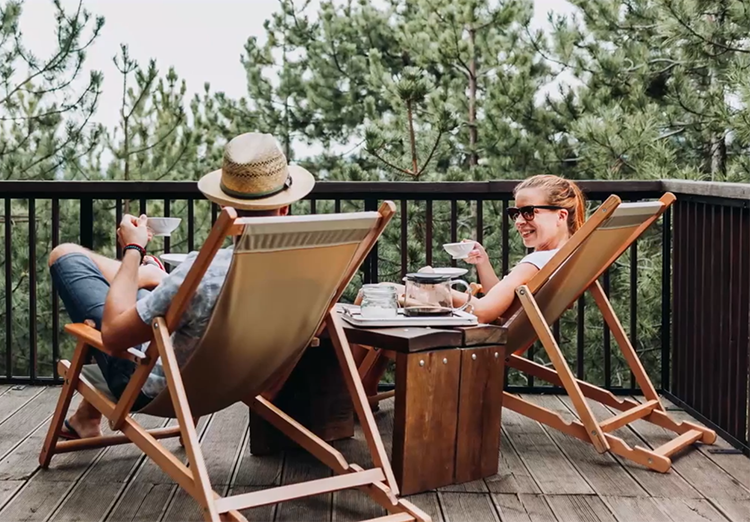 couple sits on deck chairs on patio