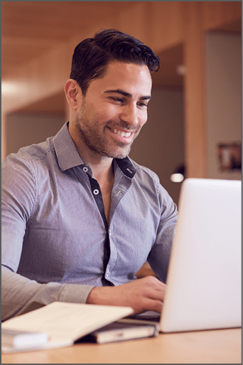 Businessman At Desk In Modern Office Work Space With Laptop