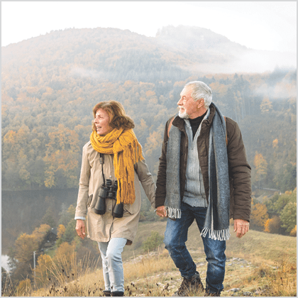 Active senior couple on a walk in a beautiful autumn nature.