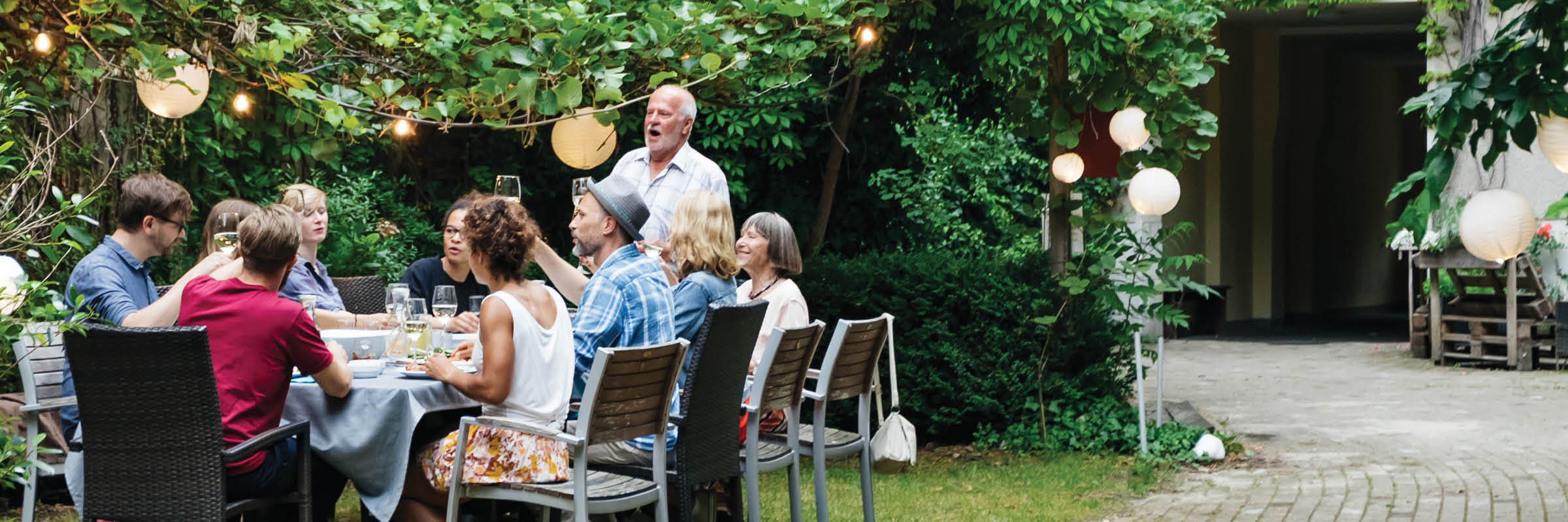 Image of large group of people dining outdoors.