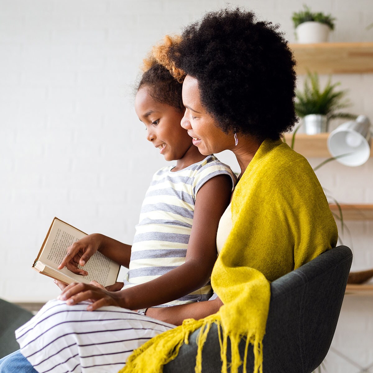 African American mother and daughter reading a book together