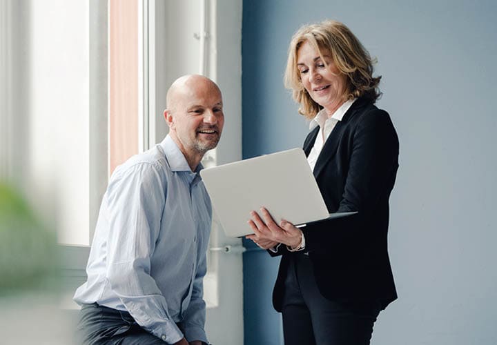 two colleagues looking a laptop together